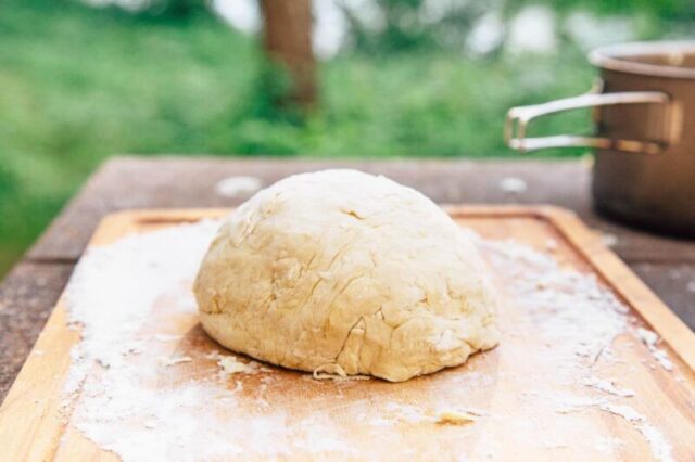 Тесто для пиццы на деревянной разделочной доске