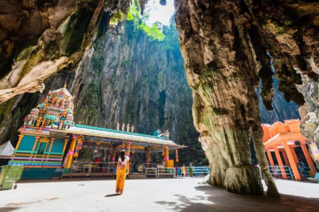 Молодая азиатская женщина посещает пещеры Бату, Куала-Лумпур, Малайзия