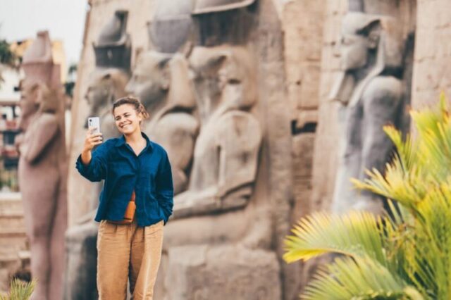 Женщина делает селфи, исследуя древние храмы Луксора в Египте. 2040403731 Женщина делает селфи, исследуя древние храмы Луксора в Египте. - стоковое фото Женщина делает селфи, исследуя древние храмы Луксора в Египте.