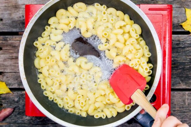 Смешивание макарон в сковороде