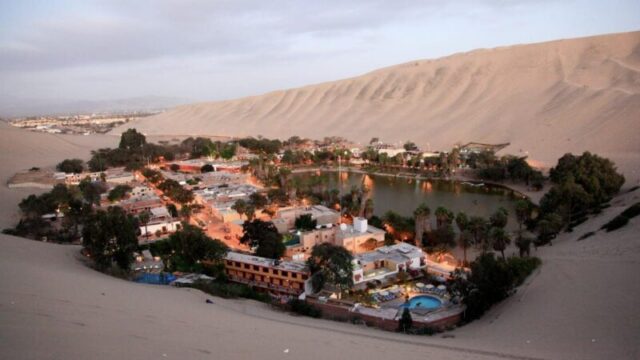 Вид на Уакачину в сумерках, оазис в пустыне Перу, который предлагает комфорт туристам; Shutterstock ID 1143789833; purchase_order: 65050 - Digital Destinations and Articles; job: наше редакционное Online Editorial; client: Однодневные поездки из Лимы; other: Брайан Хили 1143789833 приключения, америка, атакама, фон, красивый, багги, пустыня, направление, сухой, дюна, дюны, горячий, Уакачина, Ика, лагуна, пейзаж, природа, оазис, на свежем воздухе, перу, песок, сэндбординг, живописный, небо, юг, лето, закат, туризм, путешествия, деревня, теплый, вода Вид на Уакачину в сумерках, оазис в пустыне Перу, который предлагает комфорт туристам