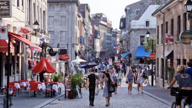 Горизонтальный вид на мощеные улицы, заполненные туристами, в Старом Монреале